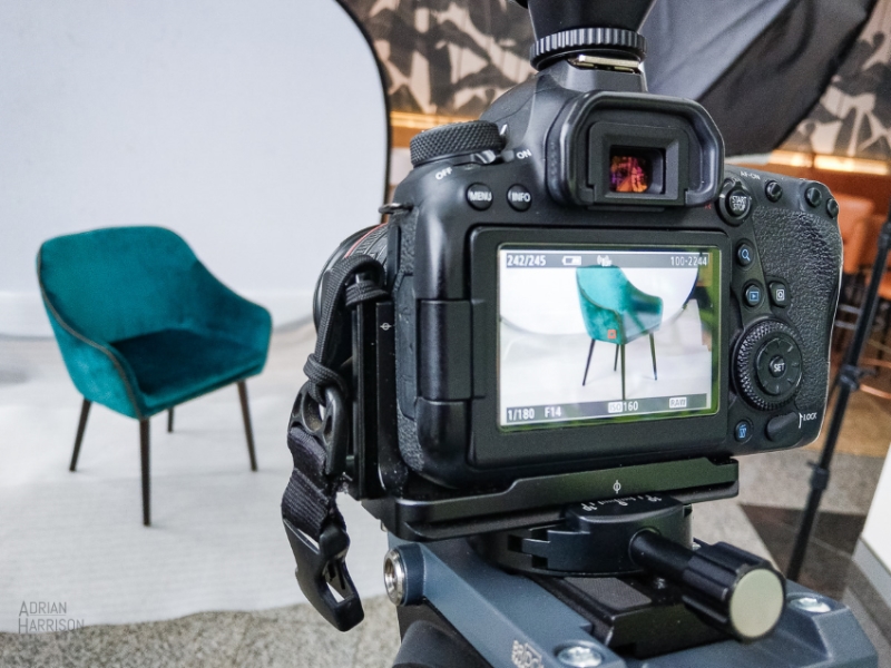 Shows a behind the scenes look of a furniture photoshoot. Chair and camera with the resulting image. 