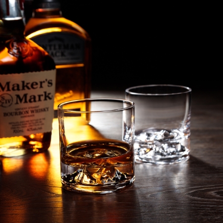 Ecommerce lifestyle product photography with props. Whiskey with whiskey glasses on a dark bar.