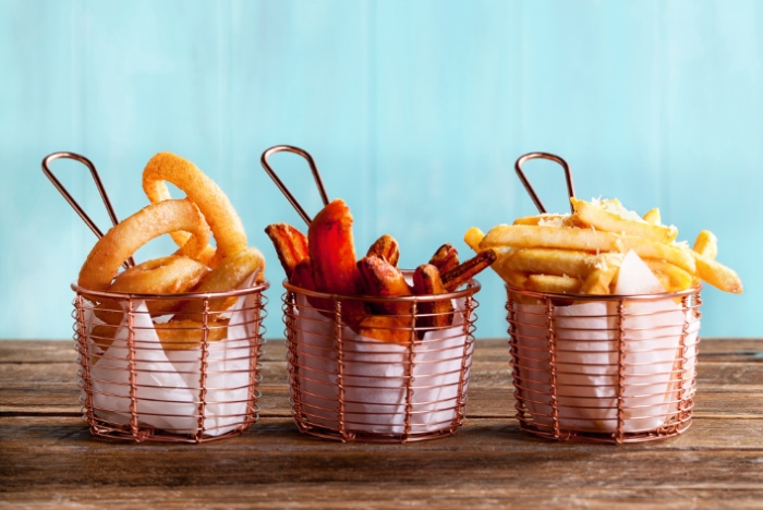 Commercial food photography showing onion rings, sweet potato fries and french fries.