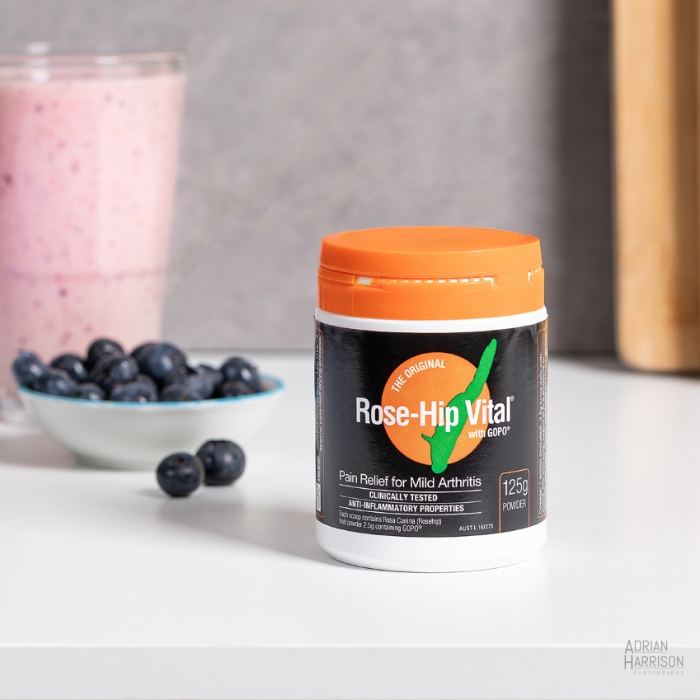 Styled product photo of a supplement with food in the background.