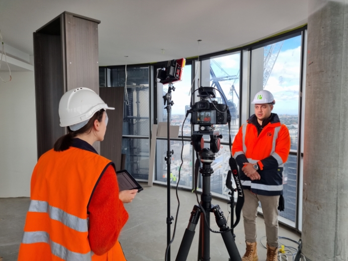 Videography of a construction worker. Man being interview by a lady in an unfinished building in Zetland, Sydney