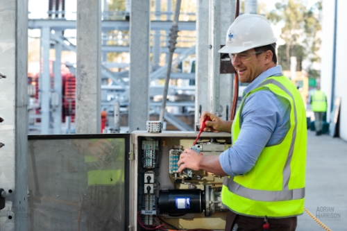Electrician on a construction site working on a distribution board.