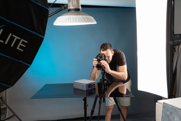 Photographer Adrian in an ecommerce product photography studio, in Sydney photographing a product on a black background.