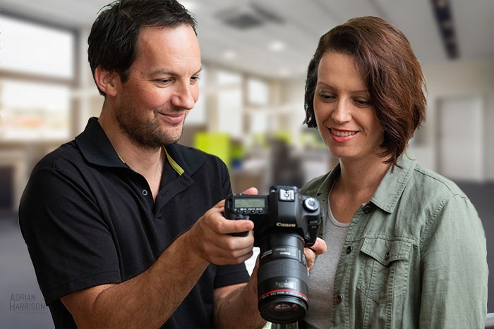 Product photographer Adrian Harrison with lady client. Photographer is showing the client images from the photoshoot.