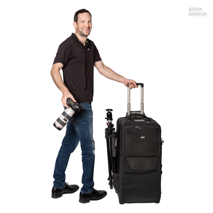 Commercial photographer Adrian Harrison with tripod, camera bag and DSLR camera ready to shoot.