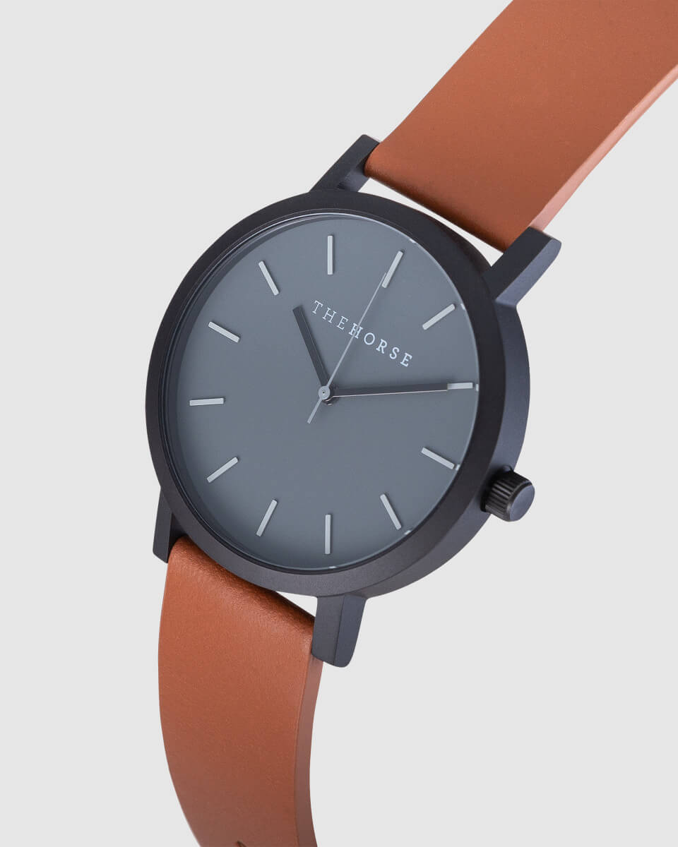 Photo of a black watch with brown strap in angled view. Product photographers in Newcastle photograph watches, jewellery, clothing and other items for ecommerce stores.