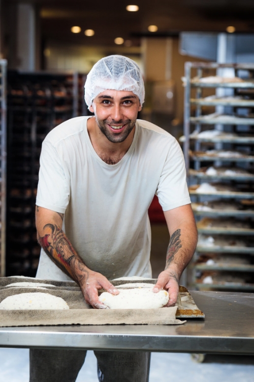Portrait of a baker shaping bread in a bakery.